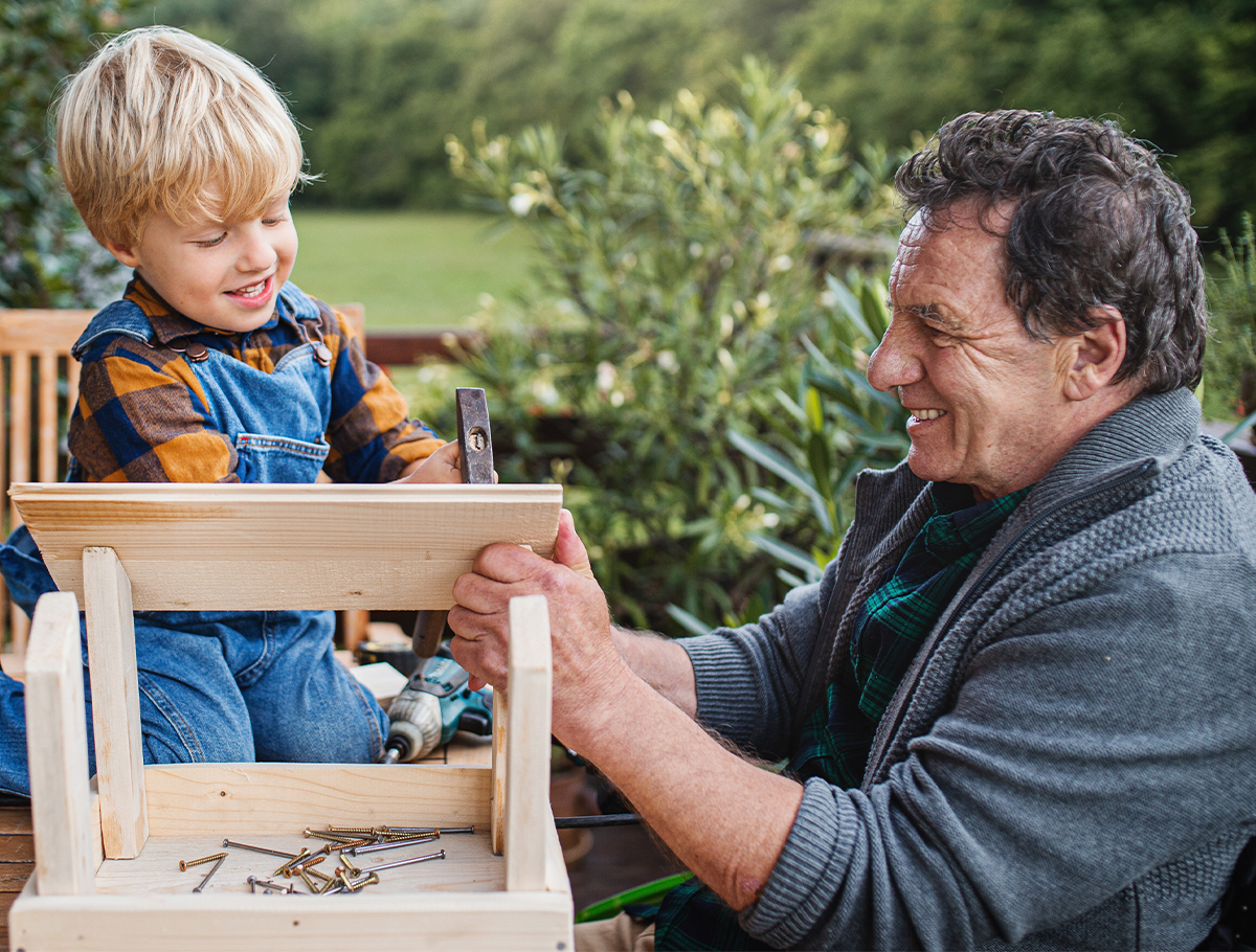 Grandfather working on small woodworking project with grandson